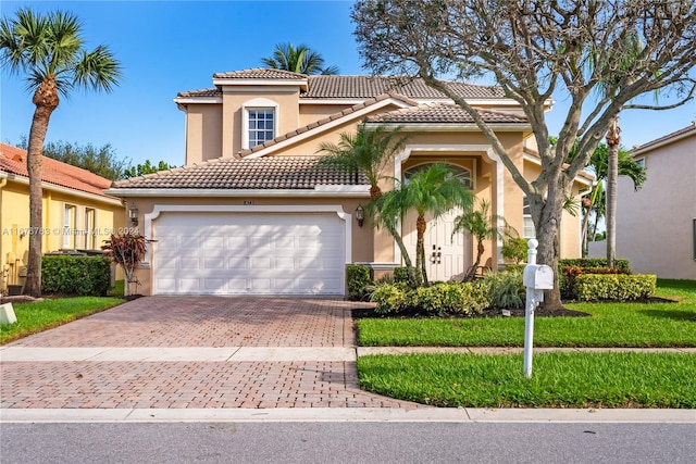 mediterranean / spanish home with a front lawn and a garage