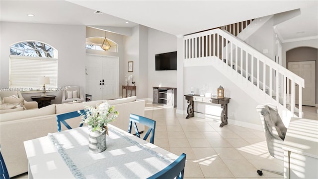 dining room featuring ornamental molding, high vaulted ceiling, and light tile patterned floors