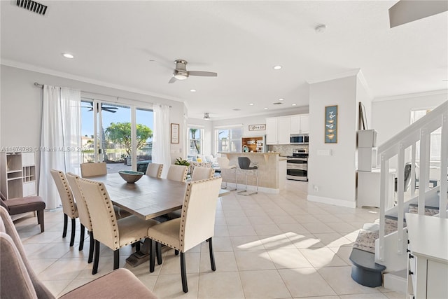 tiled dining area with ornamental molding and ceiling fan