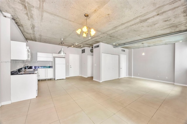 kitchen with hanging light fixtures, light tile patterned floors, white cabinetry, sink, and white appliances