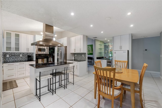 kitchen featuring white cabinetry, island range hood, stainless steel appliances, and a kitchen island