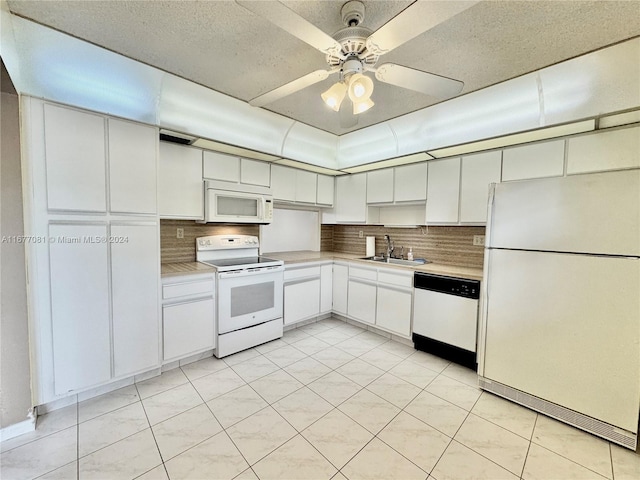 kitchen featuring white cabinets, backsplash, and white appliances