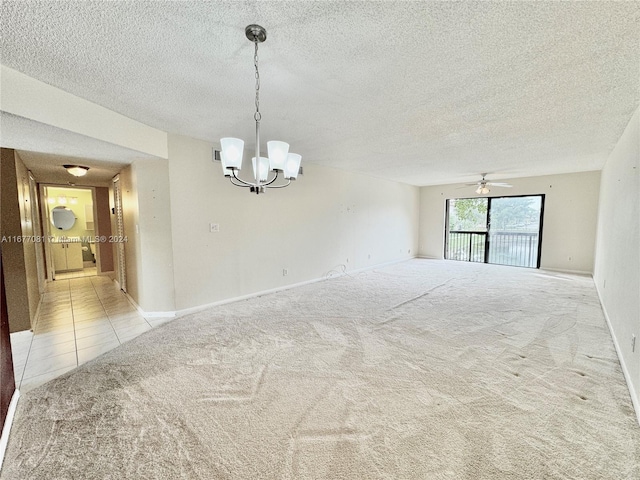 carpeted spare room featuring a textured ceiling and ceiling fan with notable chandelier