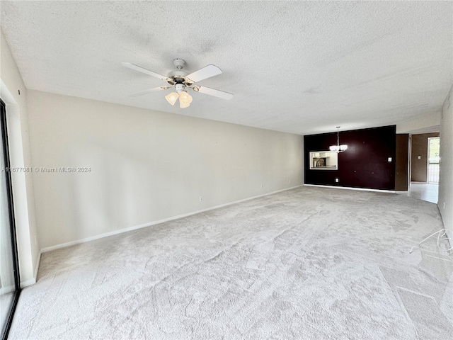 carpeted spare room featuring a textured ceiling and ceiling fan