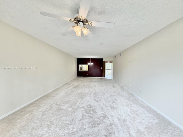 carpeted spare room with ceiling fan and a textured ceiling