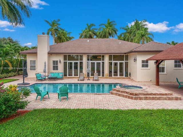 view of pool with an in ground hot tub, a yard, and a patio area