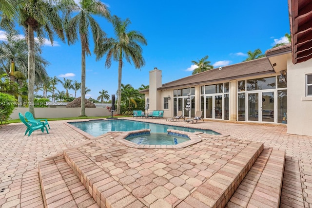 view of pool featuring a patio and an in ground hot tub