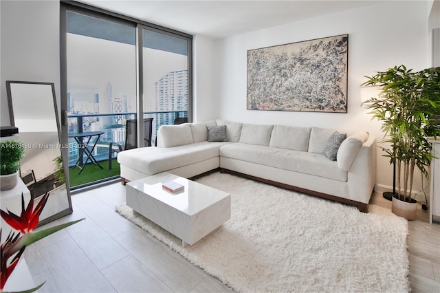 living room with light hardwood / wood-style floors and a wall of windows