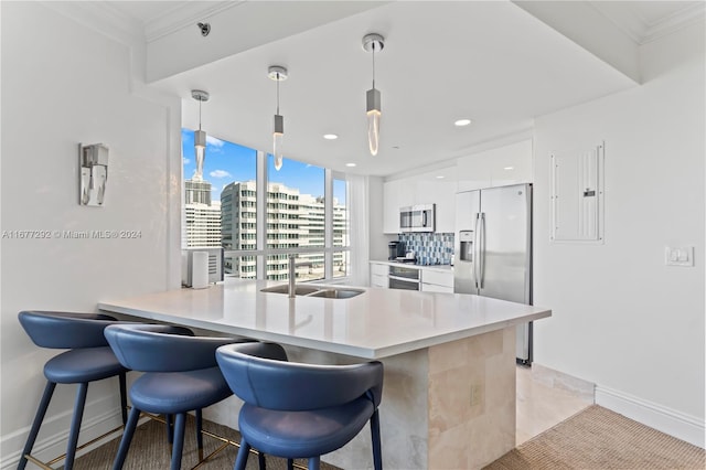 kitchen with appliances with stainless steel finishes, white cabinets, sink, and hanging light fixtures