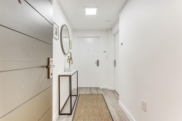 corridor with light hardwood / wood-style floors