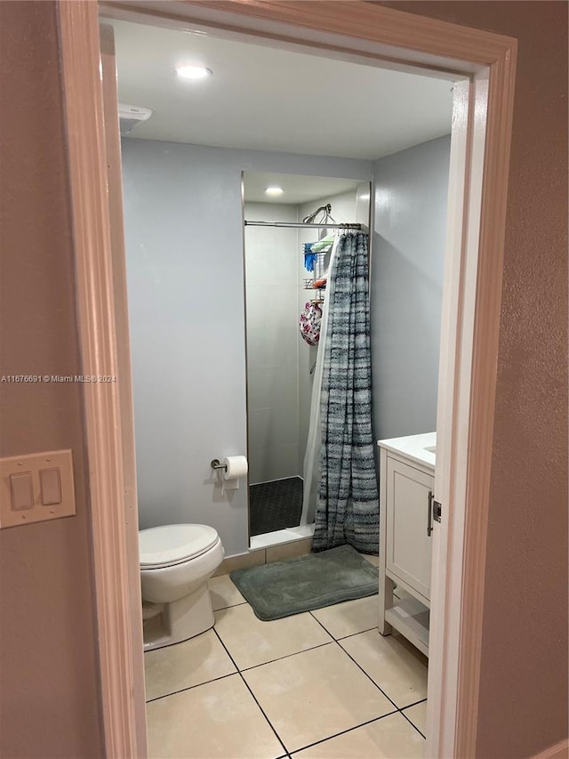 bathroom with vanity, curtained shower, toilet, and tile patterned floors