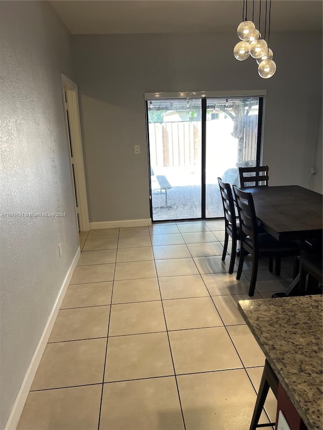 dining room featuring a notable chandelier and light tile patterned flooring