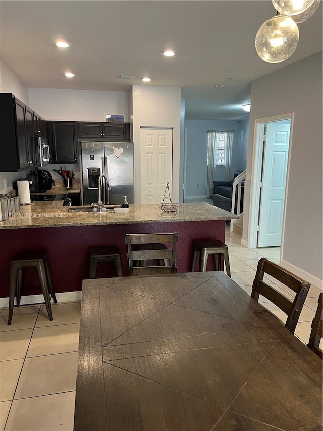 152 SE 37th Ter Unit 152, Homestead, FL 33033 - kitchen featuring dark cabinets, a peninsula, a breakfast bar area, and appliances with stainless steel finishes