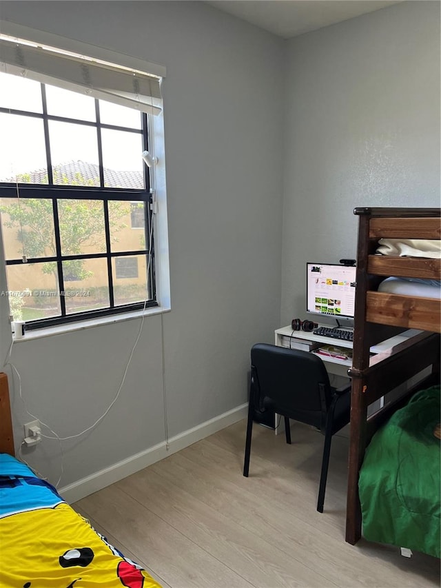 bedroom with light hardwood / wood-style floors and multiple windows