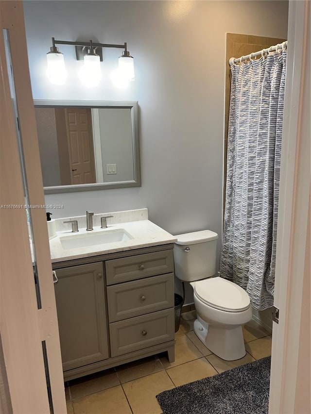 bathroom featuring walk in shower, vanity, toilet, and tile patterned floors