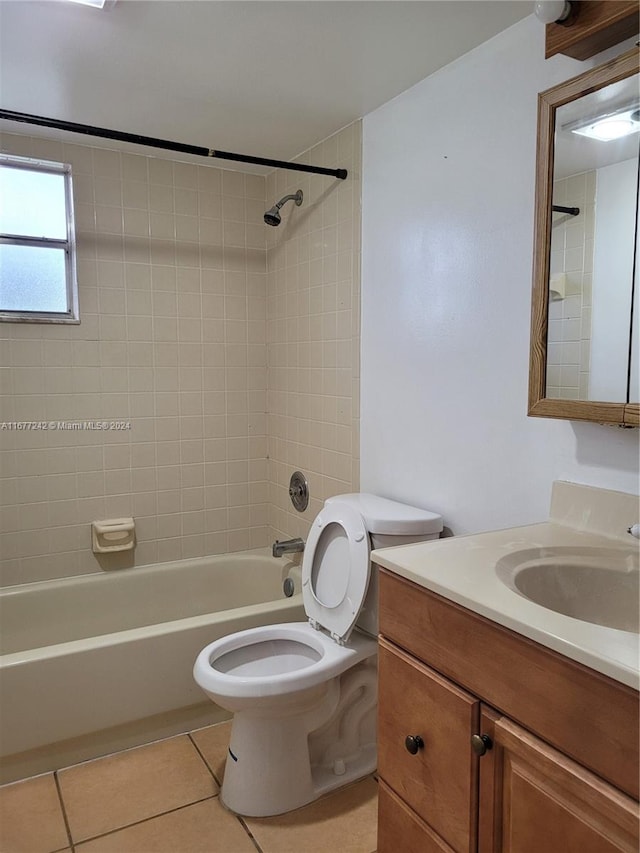 full bathroom with toilet, tiled shower / bath combo, vanity, and tile patterned flooring