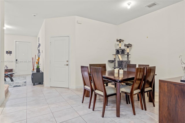 dining room featuring light tile patterned flooring, visible vents, and baseboards