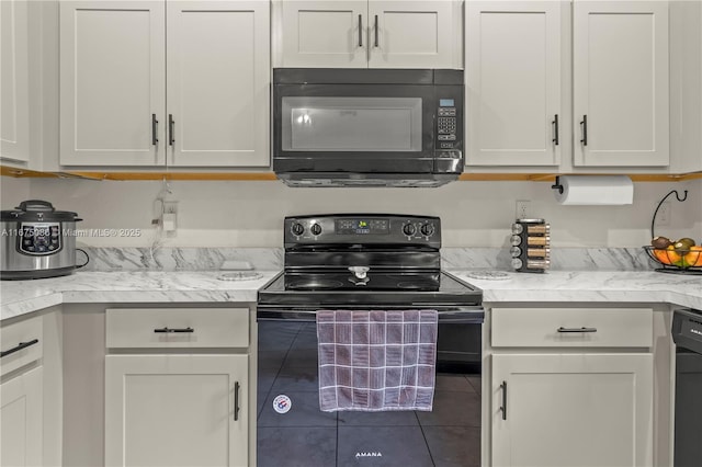 kitchen with white cabinetry, black appliances, light stone countertops, and tile patterned flooring