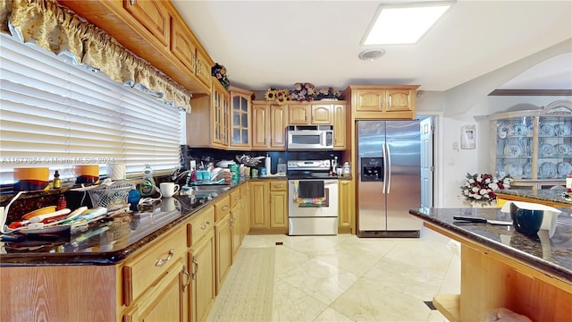 kitchen featuring sink, appliances with stainless steel finishes, and dark stone counters