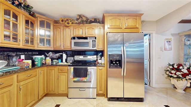 kitchen with dark stone countertops, range with electric cooktop, decorative backsplash, and stainless steel fridge