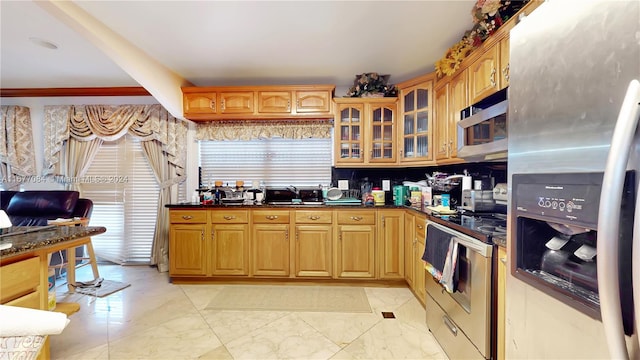 kitchen featuring sink, stainless steel appliances, a healthy amount of sunlight, and dark stone countertops