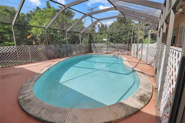 view of swimming pool with a patio area and glass enclosure