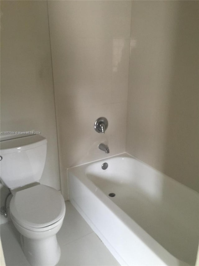 bathroom featuring toilet, tub / shower combination, and tile patterned flooring