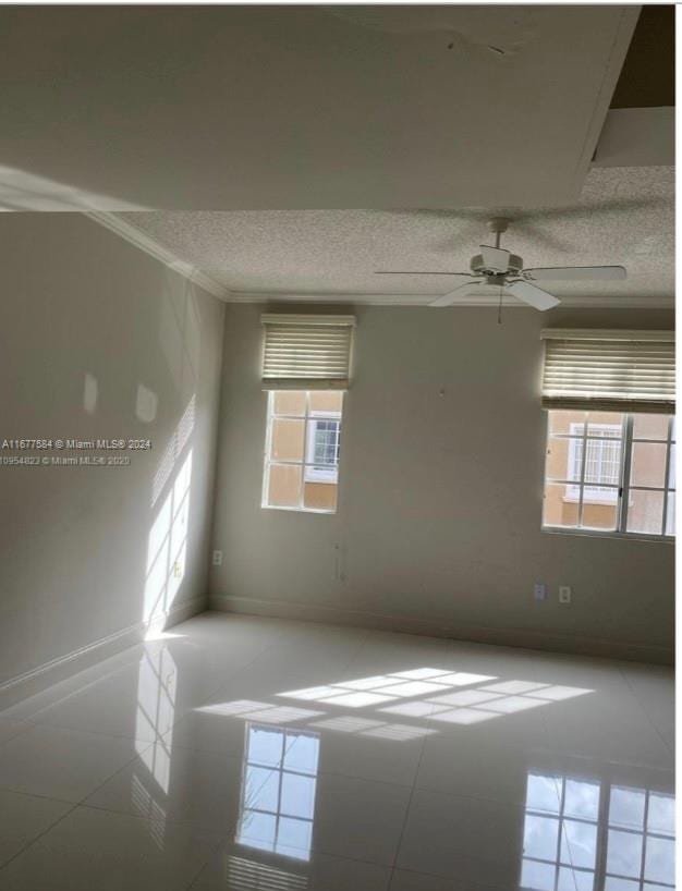 unfurnished room with ornamental molding, ceiling fan, a textured ceiling, and tile patterned flooring