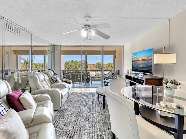 living room with ceiling fan, a healthy amount of sunlight, a textured ceiling, and floor to ceiling windows