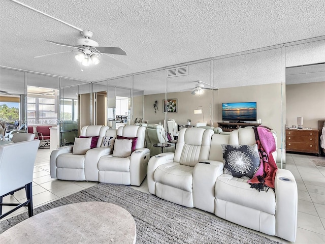 living room with a textured ceiling, light tile patterned flooring, and ceiling fan