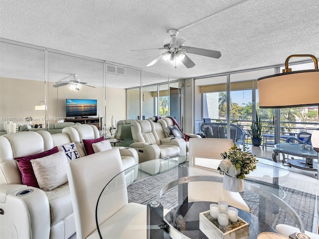 living room with a textured ceiling, floor to ceiling windows, and ceiling fan