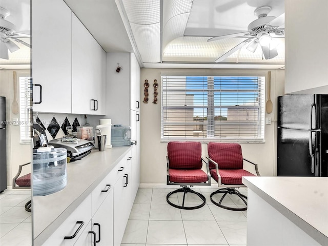 kitchen with black refrigerator, ceiling fan, light tile patterned floors, white cabinets, and stainless steel refrigerator