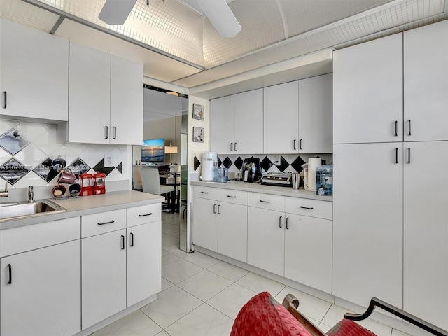 kitchen with sink, decorative backsplash, and white cabinets