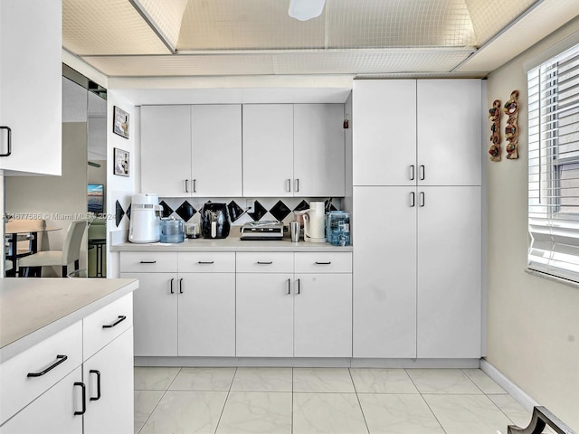 kitchen with white cabinets and tasteful backsplash