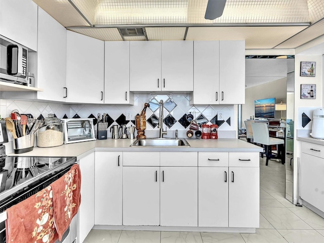 kitchen with decorative backsplash and white cabinets