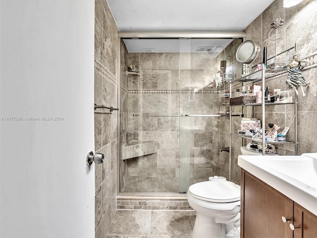 bathroom featuring tile walls, vanity, toilet, and an enclosed shower