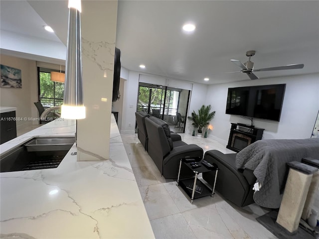 living room featuring sink, a fireplace, and ceiling fan