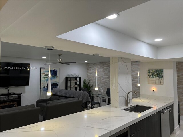 kitchen with dishwasher, sink, light stone countertops, decorative light fixtures, and ceiling fan