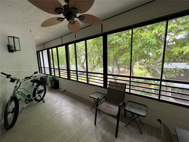 unfurnished sunroom with ceiling fan