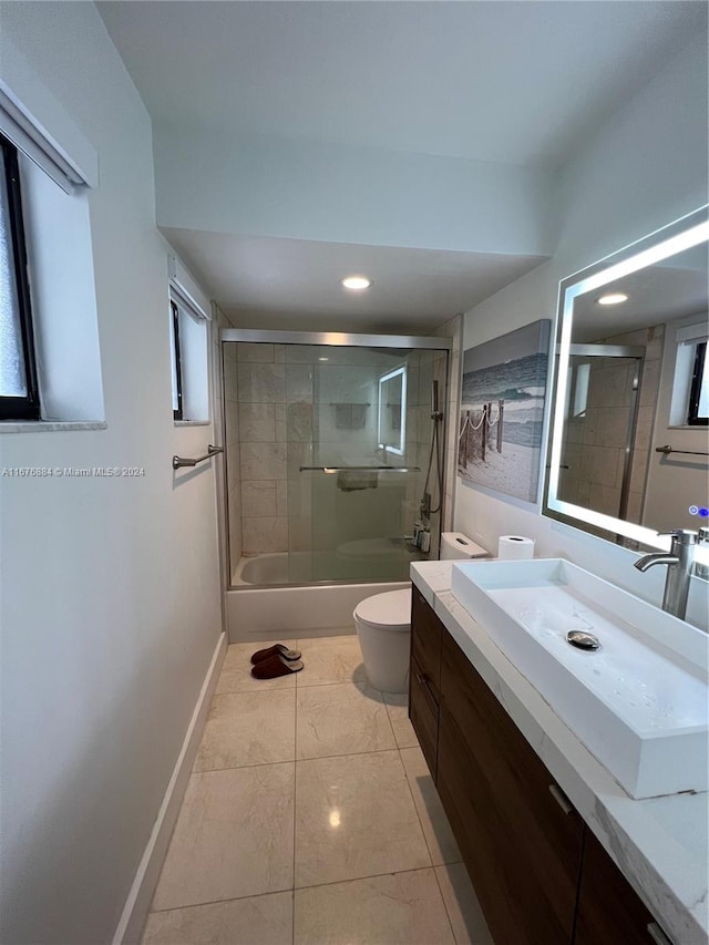 full bathroom featuring toilet, combined bath / shower with glass door, vanity, and tile patterned floors