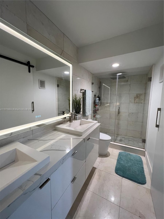 bathroom with a shower with door, tile patterned floors, toilet, tile walls, and vanity