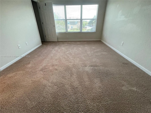 carpeted spare room with baseboards