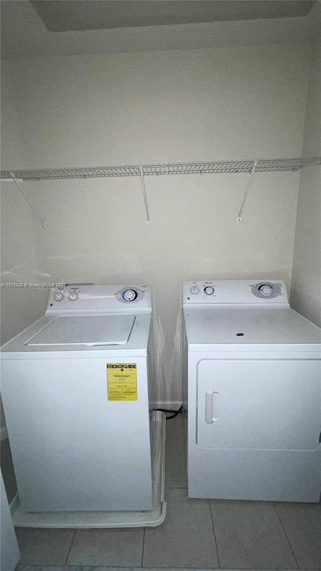 washroom with washer and clothes dryer, tile patterned flooring, and laundry area