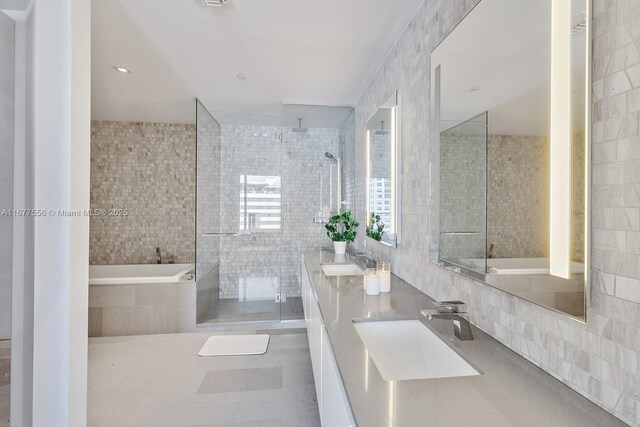 88 SW 7th St Unit 1710, Miami, FL 33130 - bathroom with tile walls, a stall shower, double vanity, and a bath
