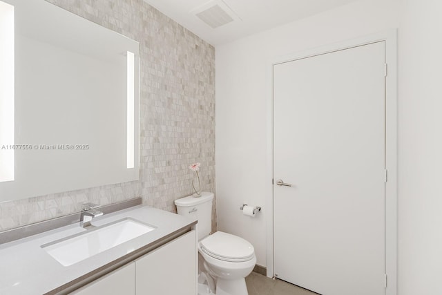 88 SW 7th St Unit 1710, Miami, FL 33130 - bathroom with tile walls, toilet, vanity, and decorative backsplash