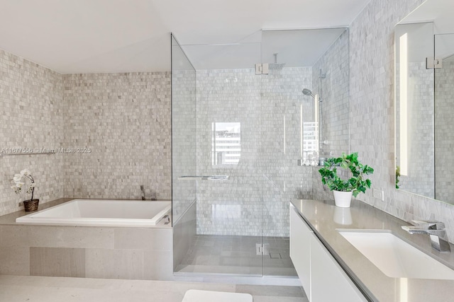 bathroom featuring tile walls, vanity, and plus walk in shower