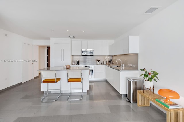 88 SW 7th St Unit 1710, Miami, FL 33130 - kitchen with stainless steel appliances, a sink, modern cabinets, and white cabinetry