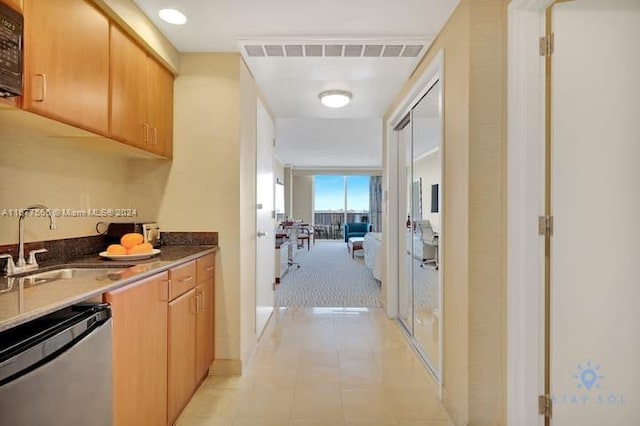 corridor with light tile patterned floors and sink