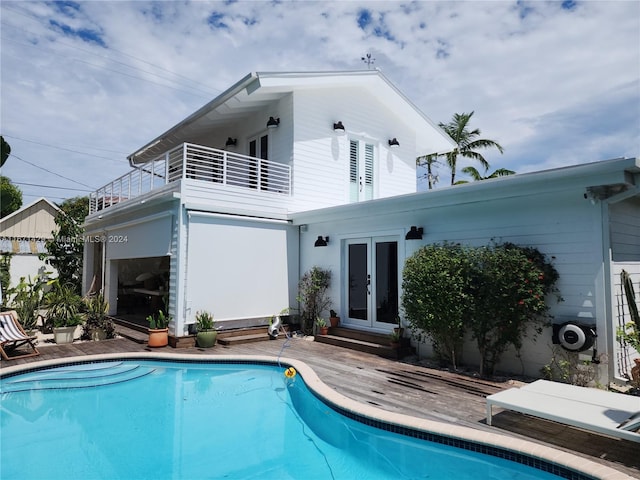 back of property featuring a balcony and french doors