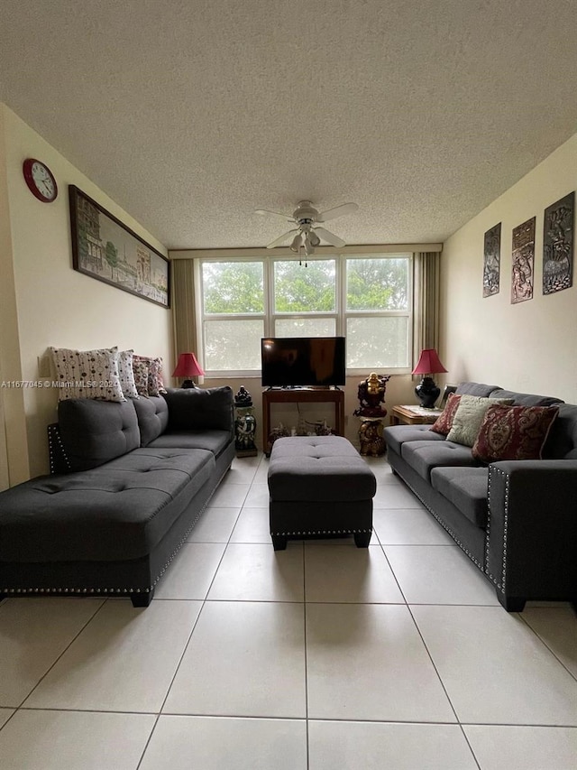 living room featuring ceiling fan, a textured ceiling, and tile patterned flooring